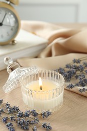 Beautiful burning candle, flowers and decor on wooden table