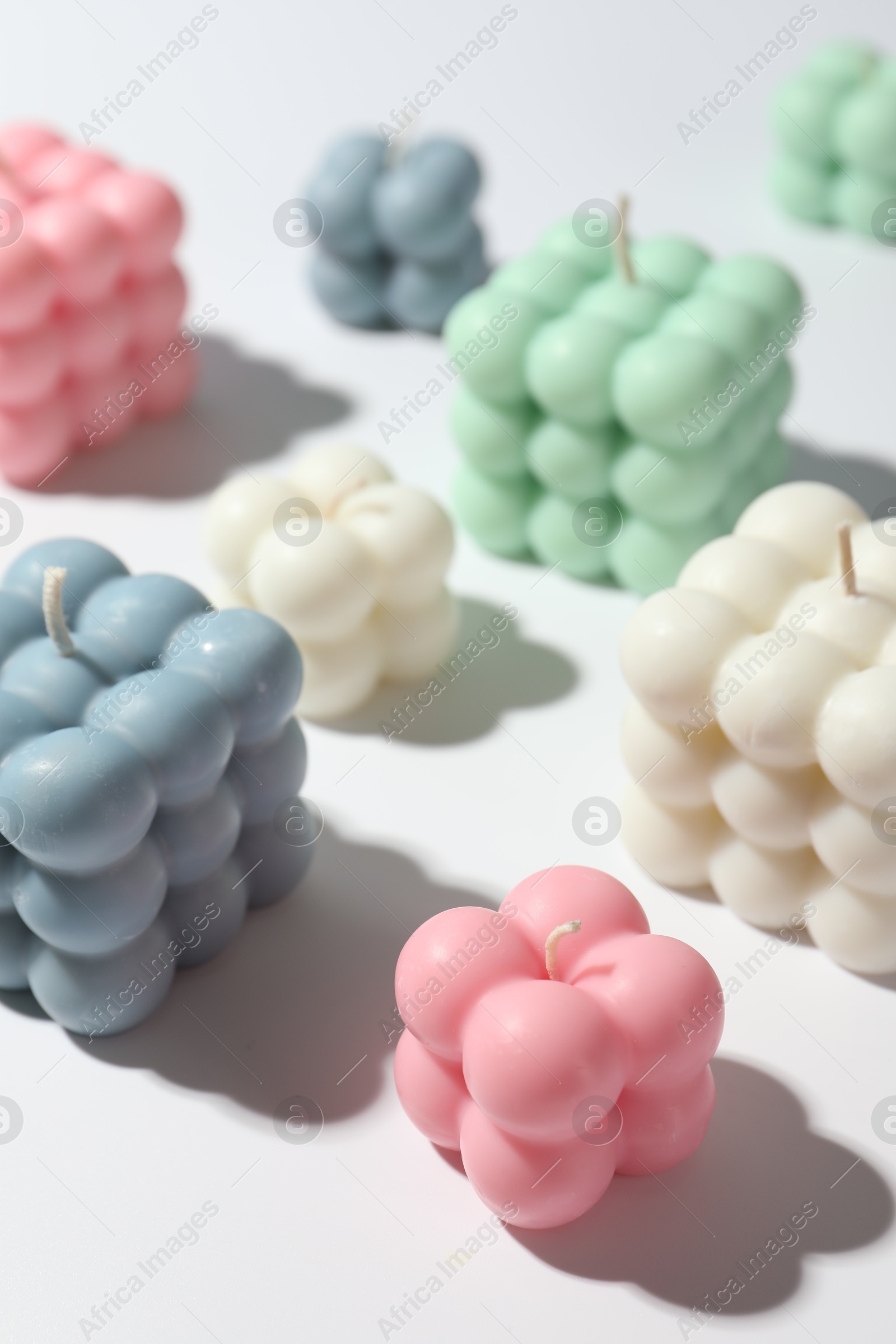 Photo of Many beautiful bubble candles on white table