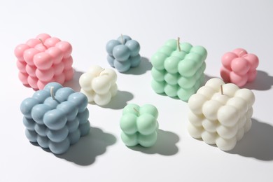 Photo of Many beautiful bubble candles on white table