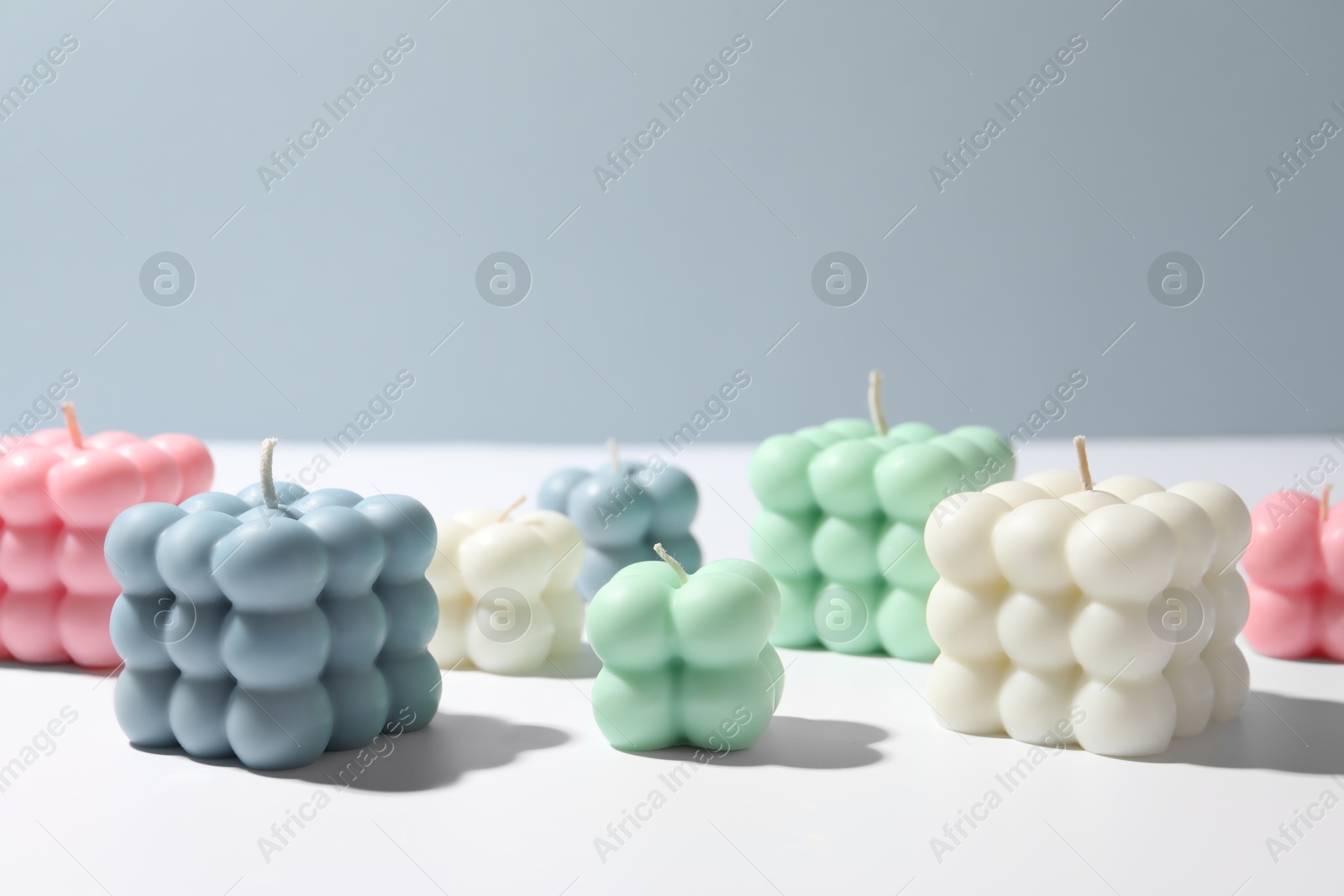 Photo of Beautiful bubble candles on white table, space for text