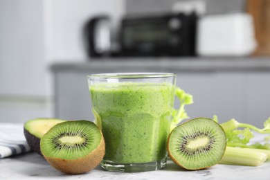 Photo of Delicious green smoothie and ingredients on white table