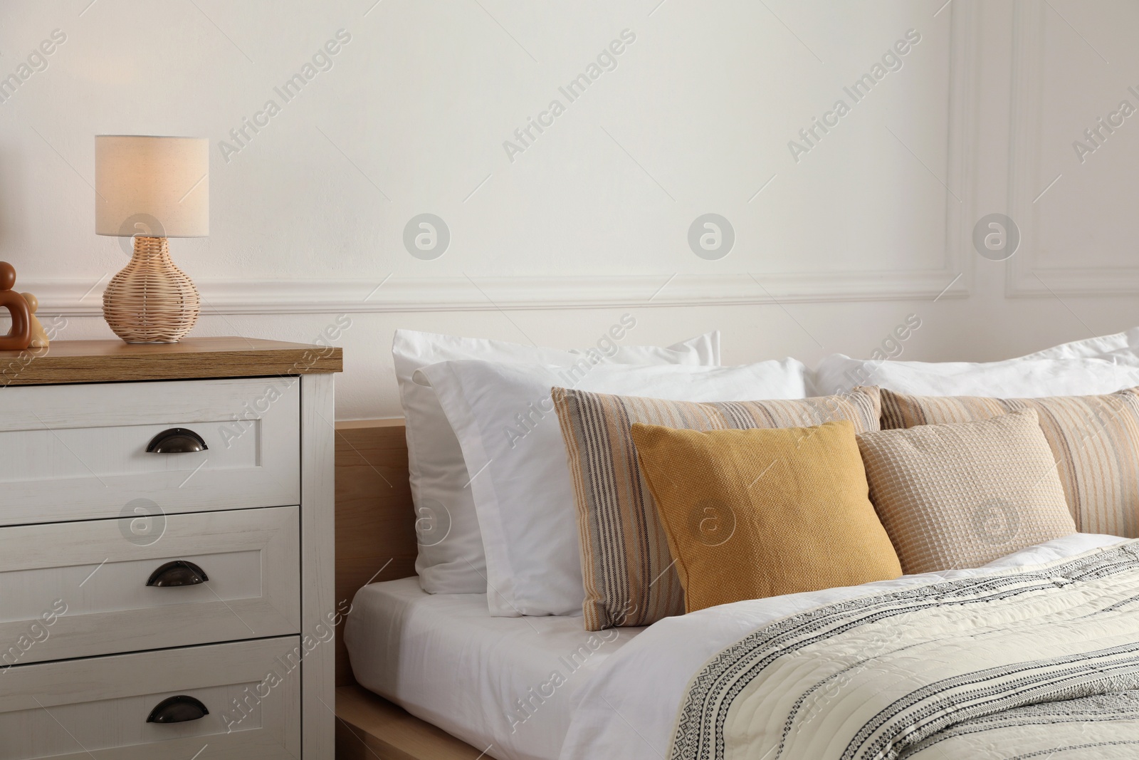 Photo of Bed with beautiful cushions in room. Interior design