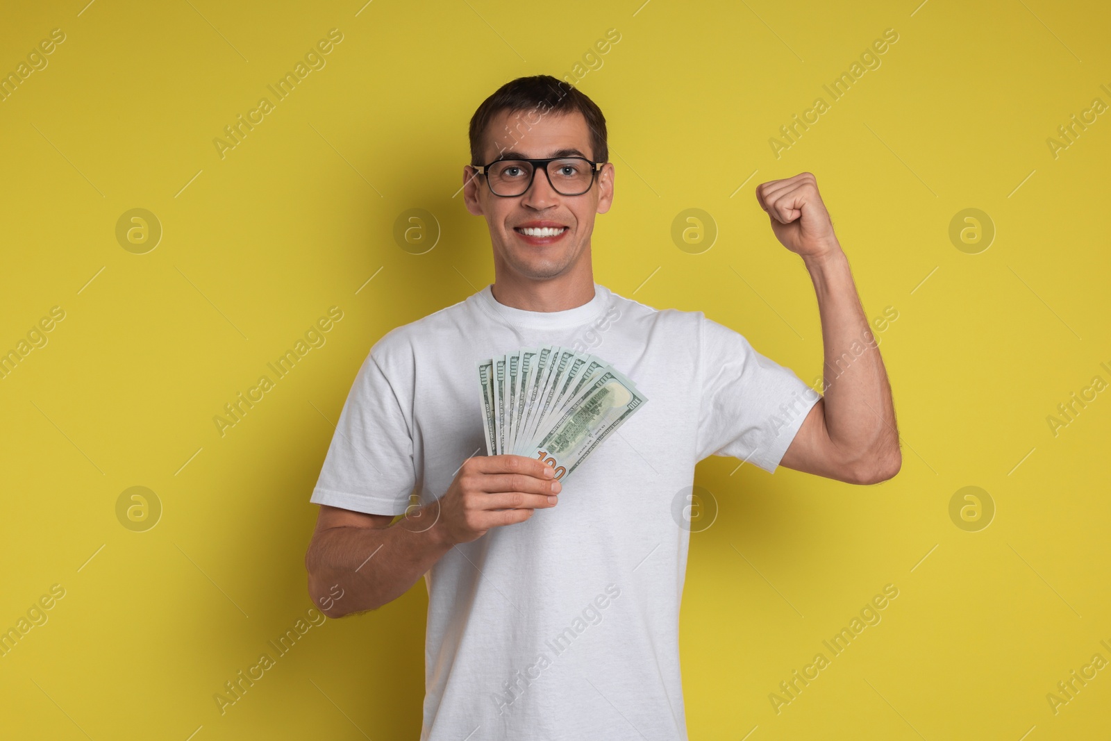 Photo of Happy man with money on yellow background