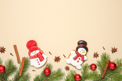 Photo of Flat lay composition with Christmas decor and delicious cookies in shape of snowmen on beige background, space for text