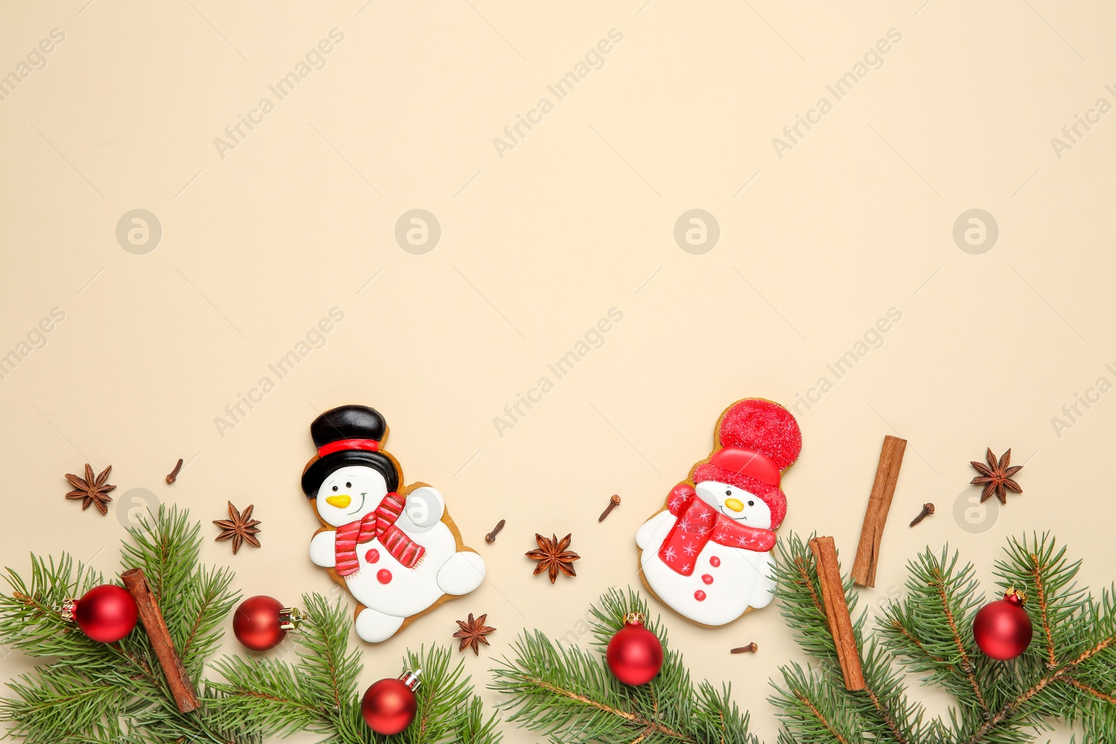 Photo of Flat lay composition with Christmas decor and delicious cookies in shape of snowmen on beige background, space for text