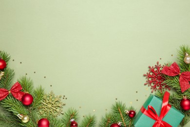 Photo of Flat lay composition with Christmas decor and gift box on green background, space for text