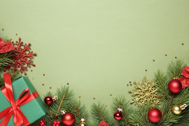 Photo of Flat lay composition with Christmas decor and gift box on green background, space for text