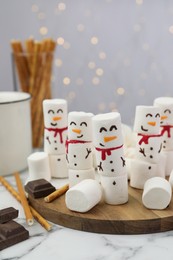 Photo of Funny snowmen made with marshmallows on white marble table