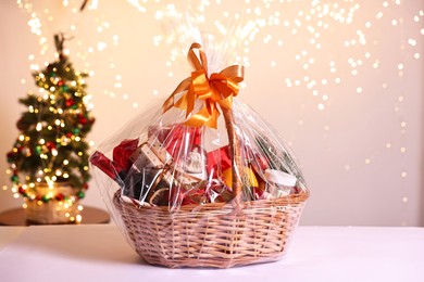 Photo of Wicker gift basket with wine on white table