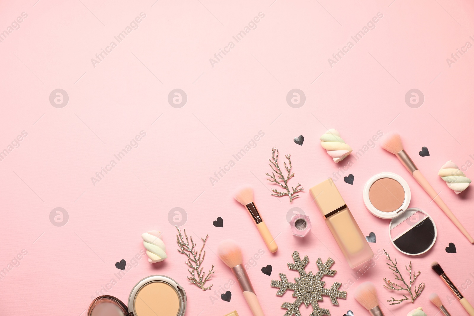 Photo of Different makeup brushes, decorative cosmetics and Christmas decor on pink background, flat lay. Space for text