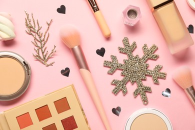 Photo of Different makeup brushes, decorative cosmetics and Christmas decor on pink background, flat lay