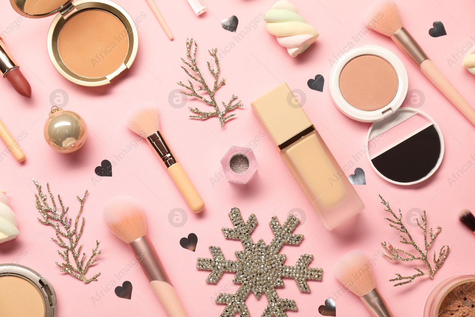 Photo of Different makeup brushes, decorative cosmetics and Christmas decor on pink background, flat lay