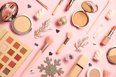 Photo of Different makeup brushes, decorative cosmetics and Christmas decor on pink background, flat lay