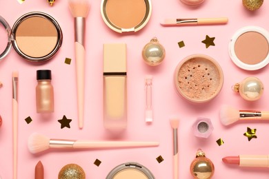 Photo of Different makeup brushes, decorative cosmetics and Christmas decor on pink background, flat lay