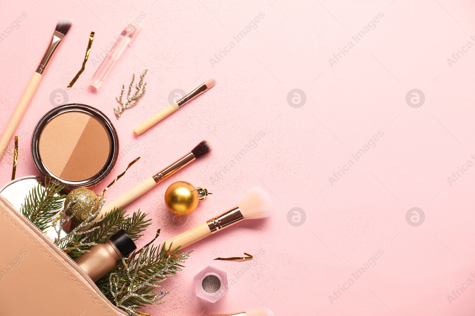 Photo of Different makeup brushes, decorative cosmetics and Christmas decor on pink background, flat lay. Space for text