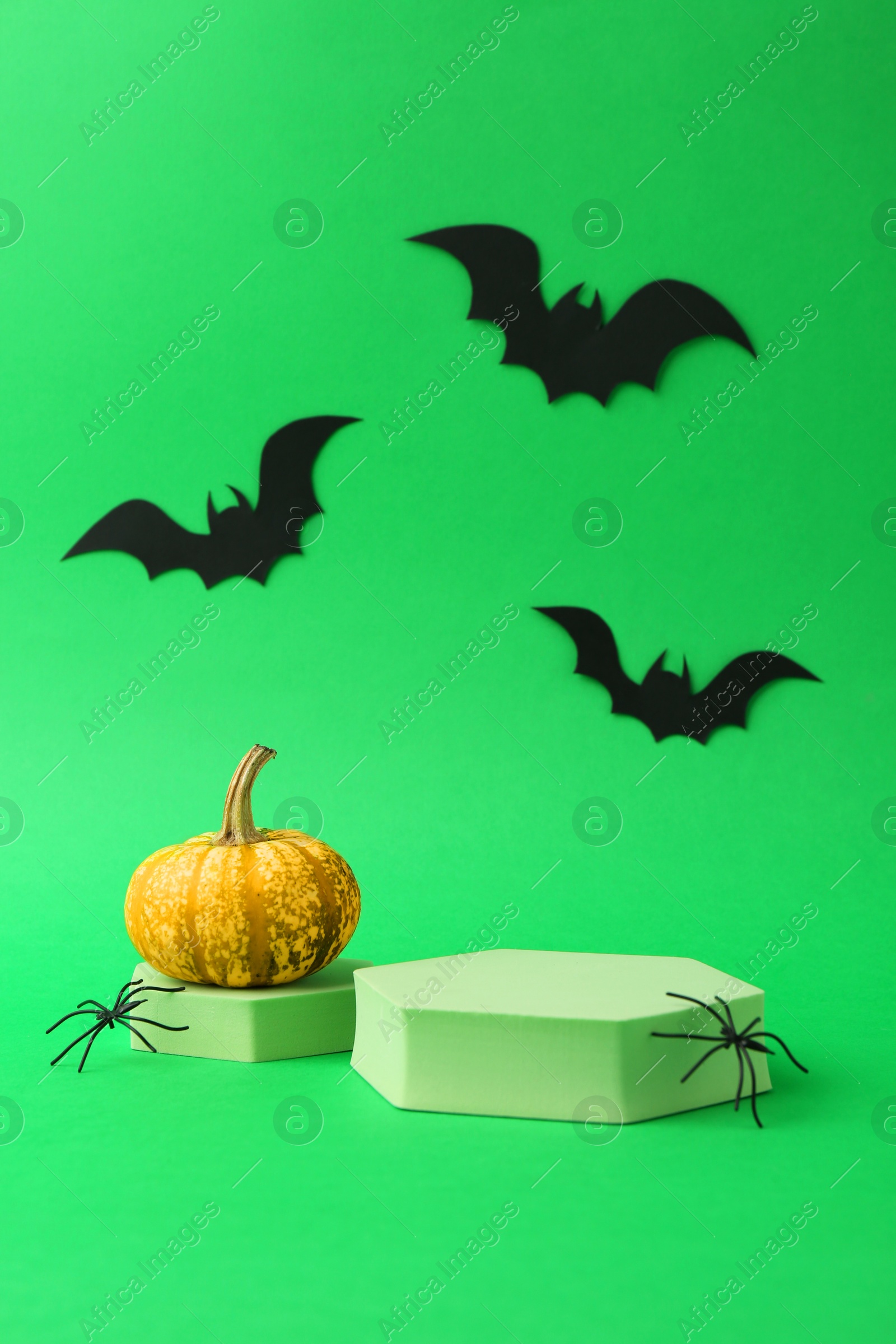 Photo of Presentation of product. Podiums and Halloween decor on green background. Space for text