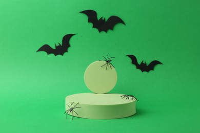 Presentation of product. Podiums and Halloween decor on green background. Space for text