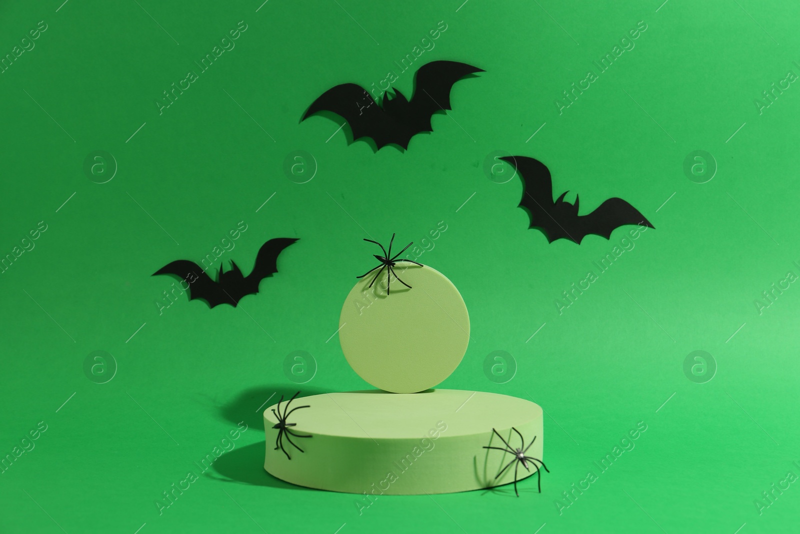 Photo of Presentation of product. Podiums and Halloween decor on green background. Space for text