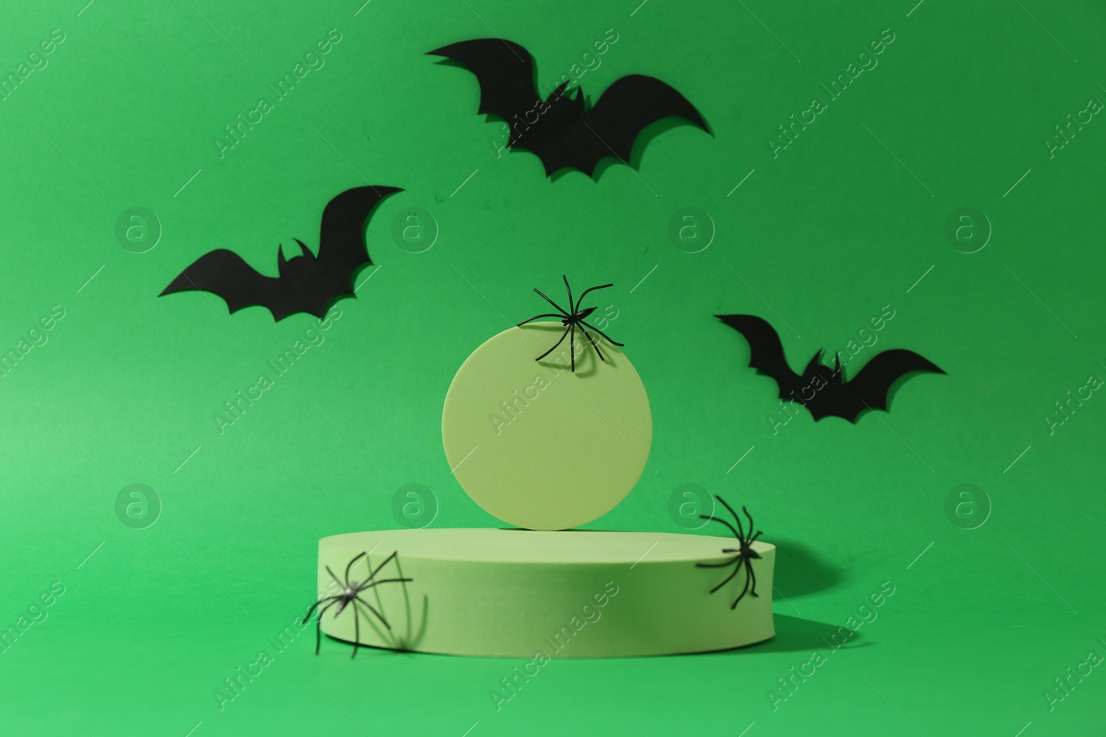 Photo of Presentation of product. Podiums and Halloween decor on green background. Space for text