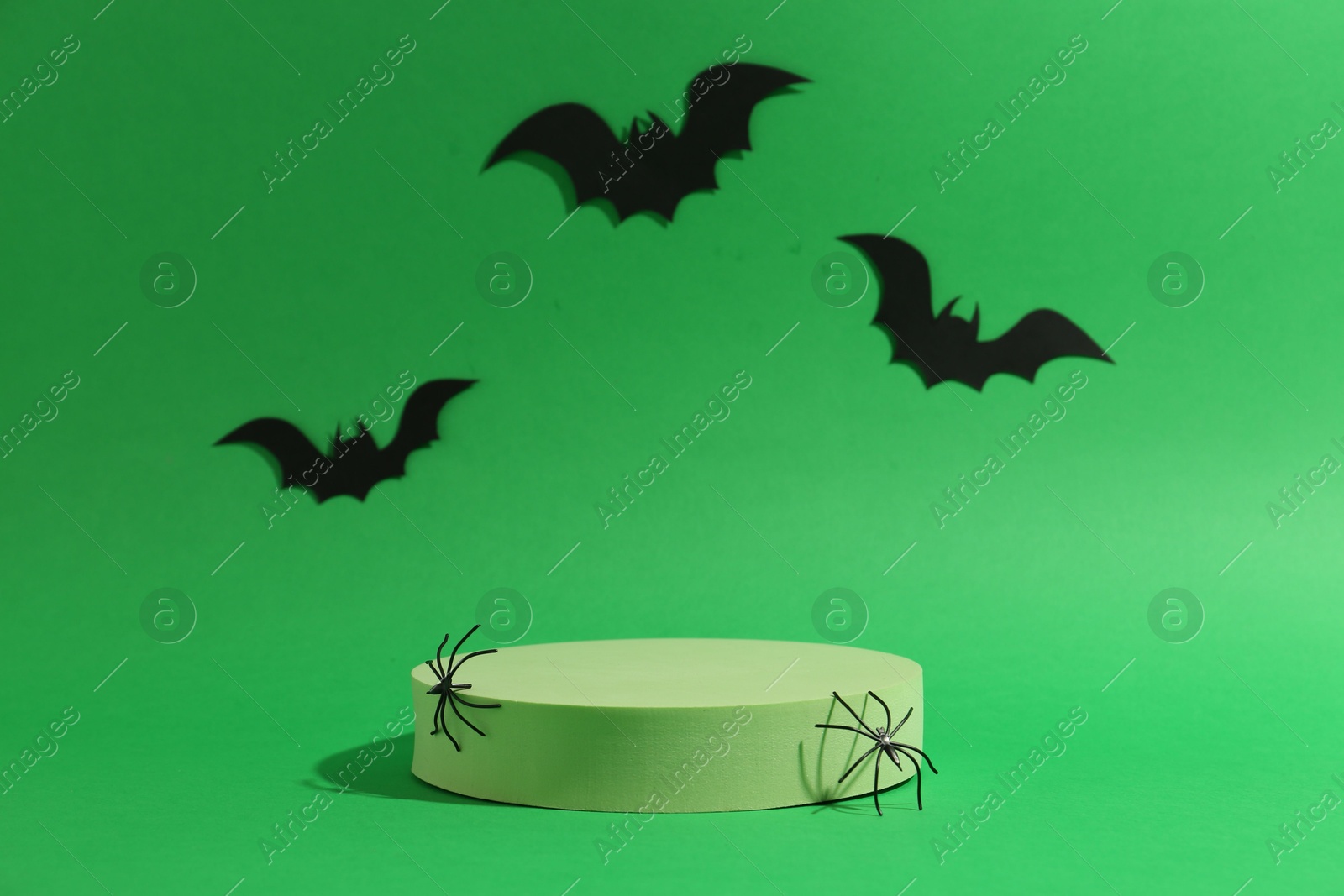 Photo of Presentation of product. Podium and Halloween decor on green background. Space for text