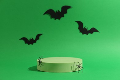 Presentation of product. Podium and Halloween decor on green background. Space for text