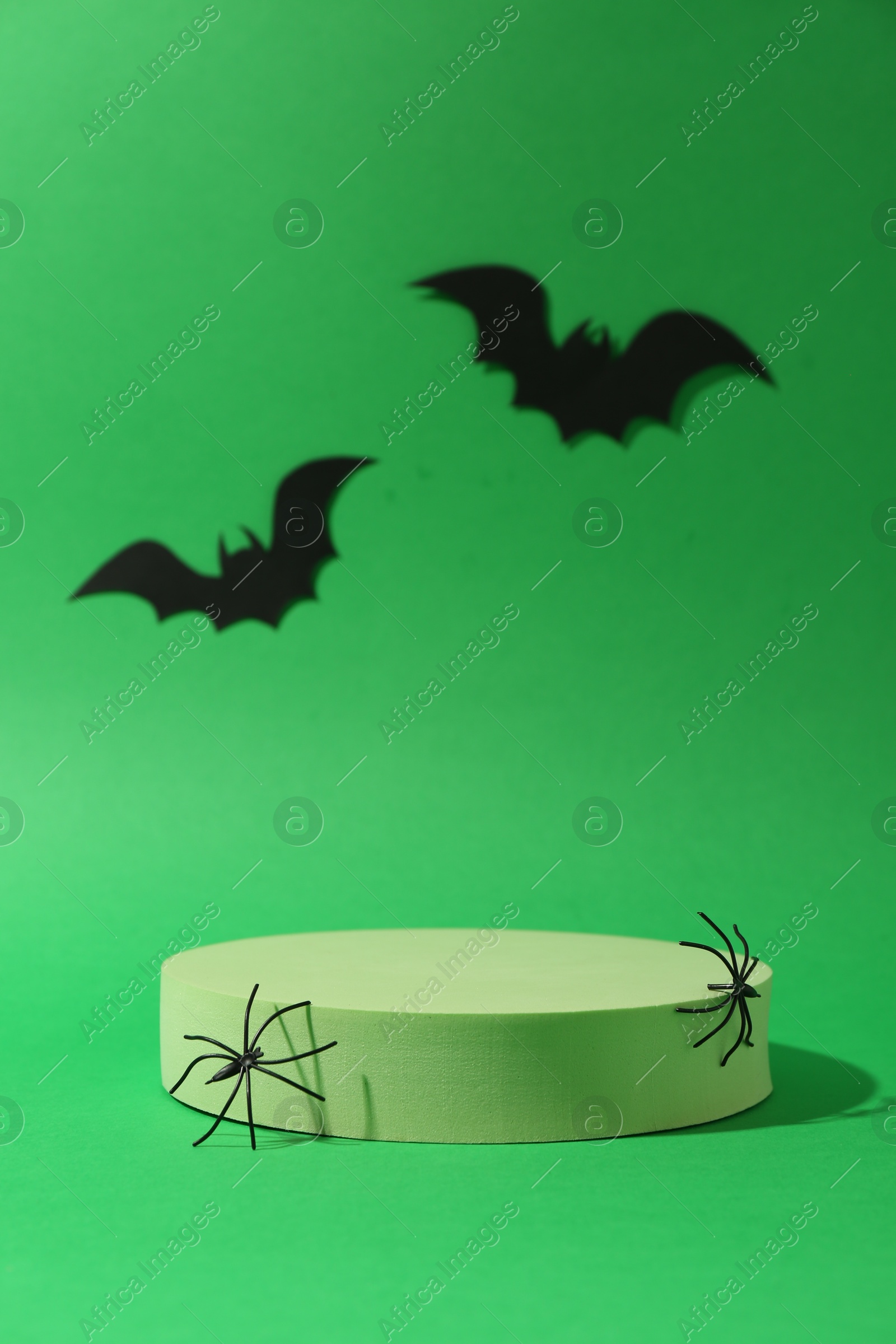 Photo of Presentation of product. Podium and Halloween decor on green background. Space for text