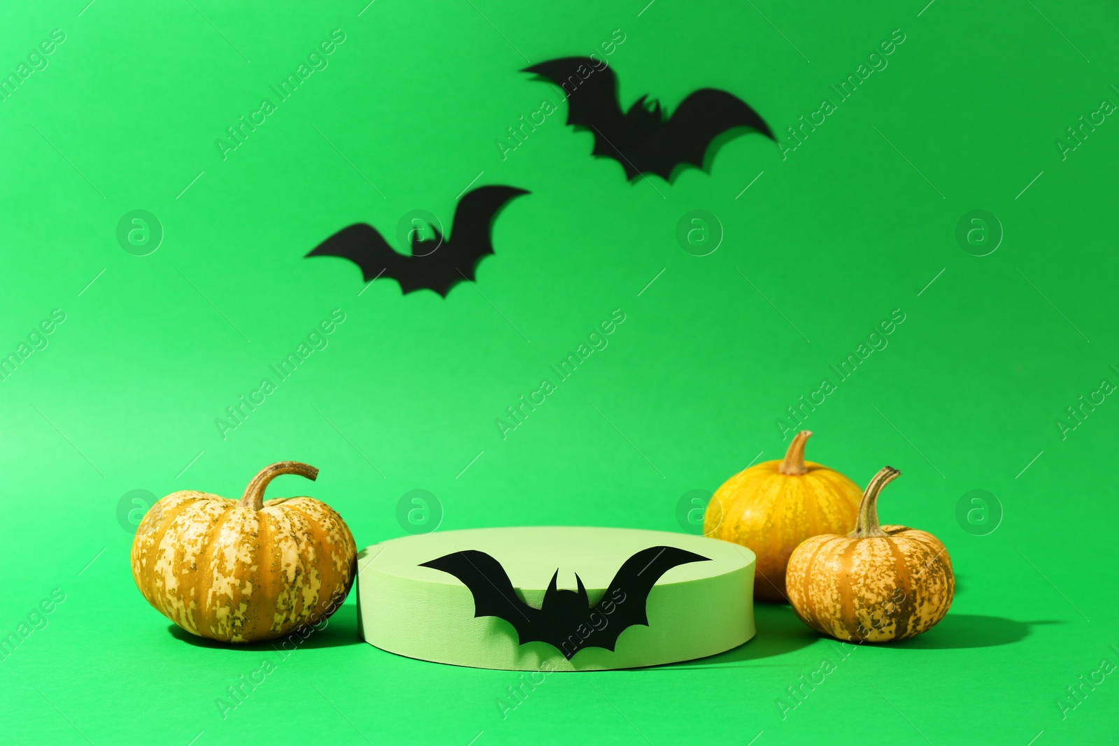 Photo of Presentation of product. Podium and Halloween decor on green background. Space for text