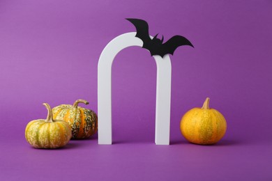 Photo of Presentation of product. Arc and Halloween decor on purple background, space for text