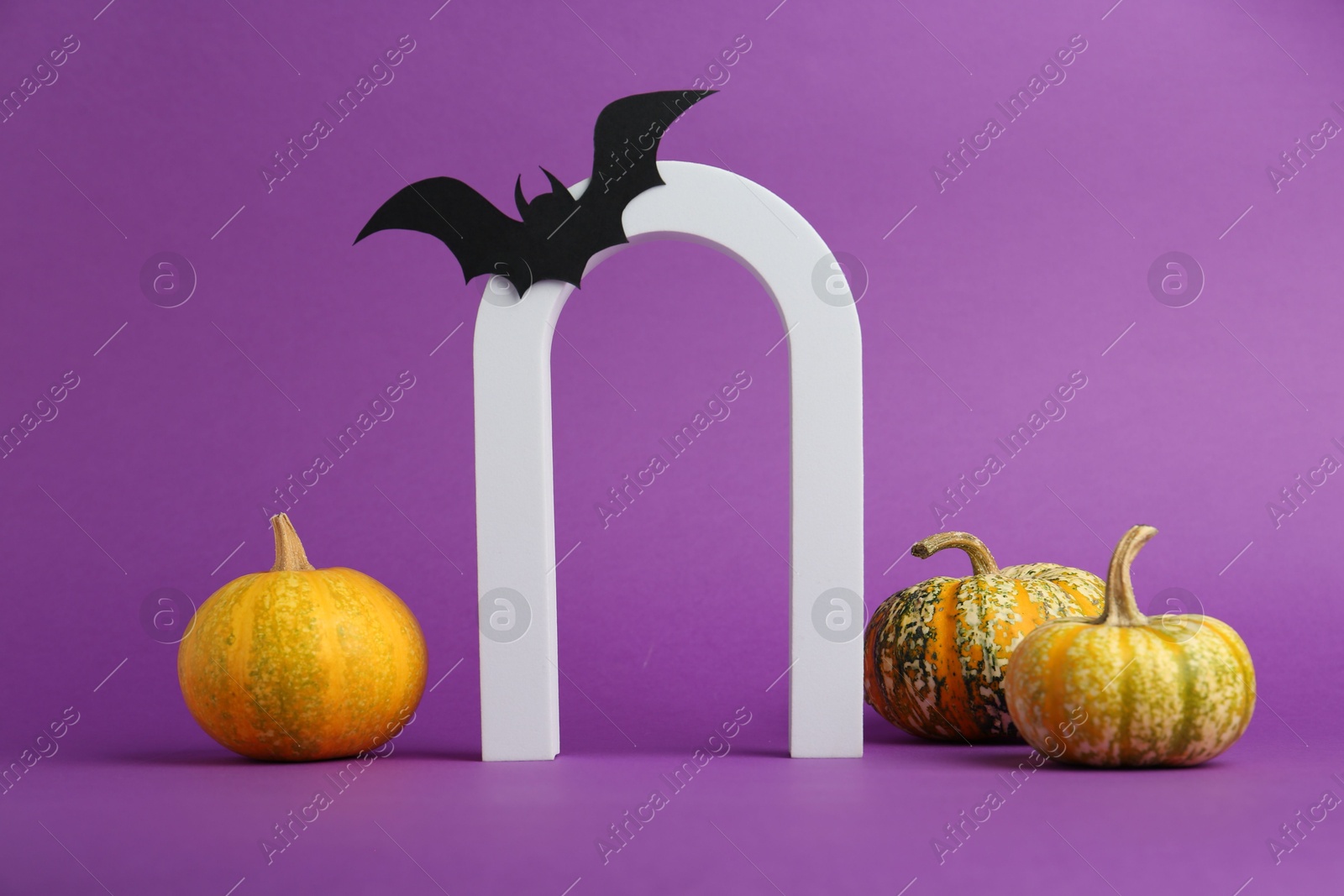 Photo of Presentation of product. Arc and Halloween decor on purple background, space for text