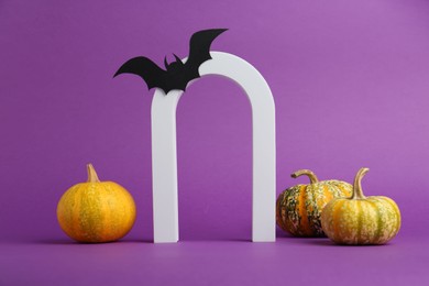 Photo of Presentation of product. Arc and Halloween decor on purple background, space for text