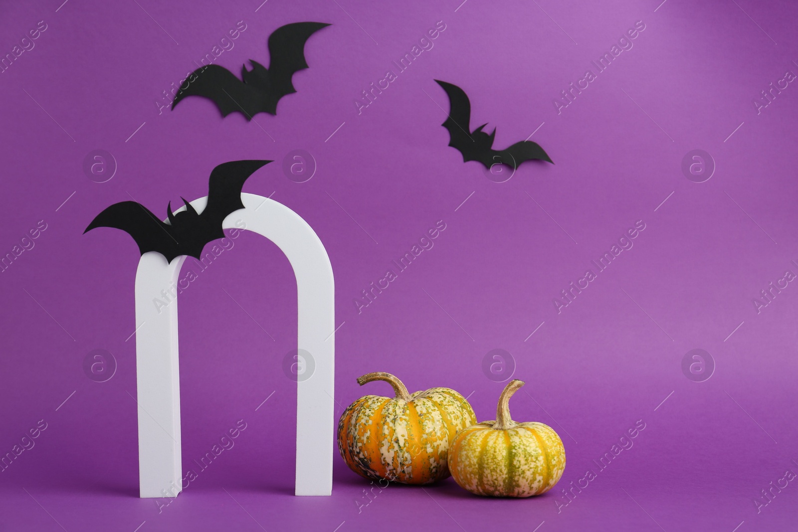 Photo of Presentation of product. Arc and Halloween decor on purple background, space for text