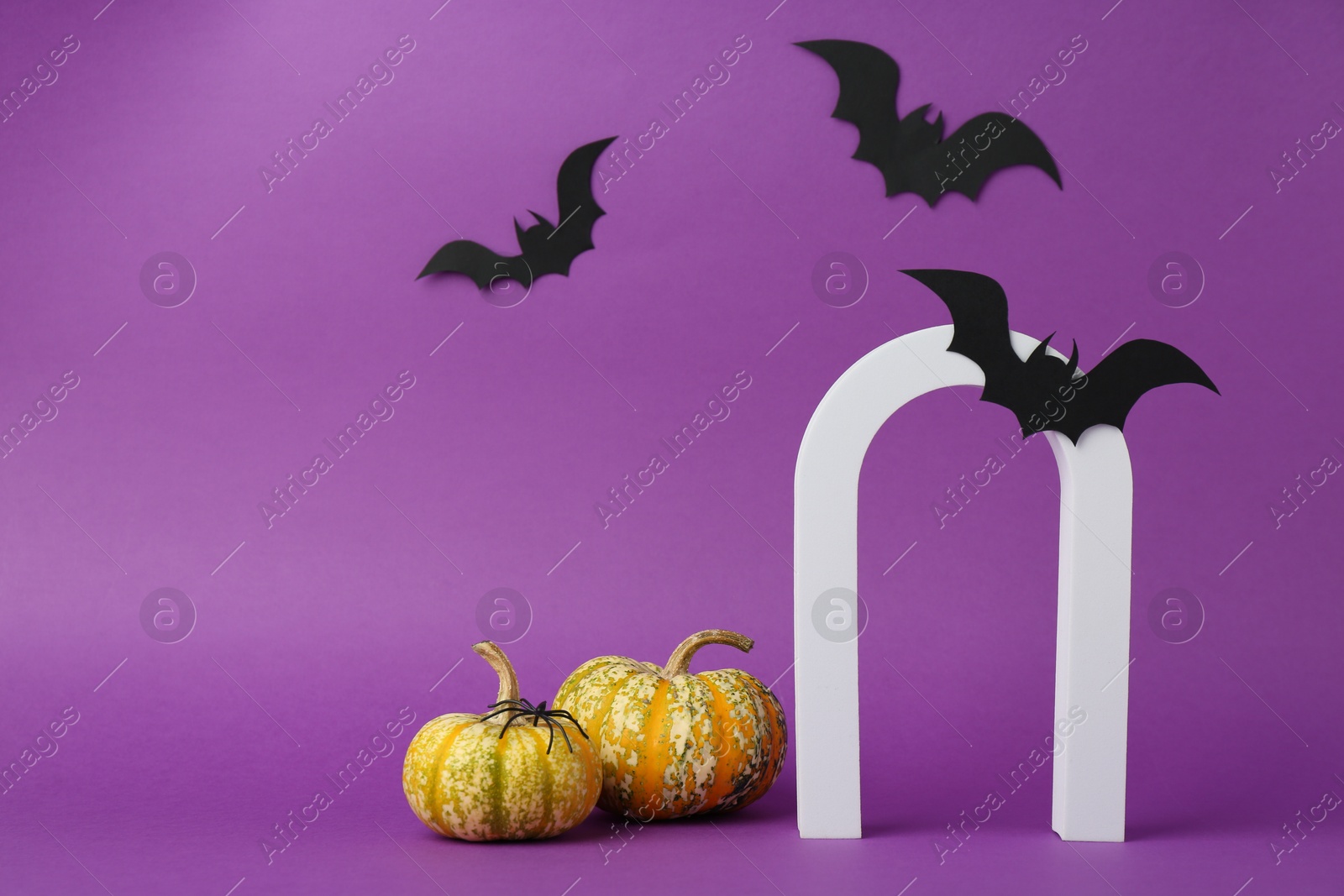 Photo of Presentation of product. Arc and Halloween decor on purple background, space for text