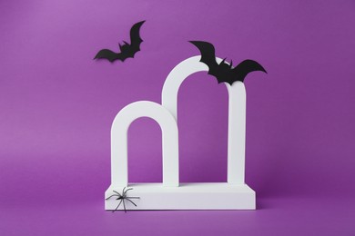 Photo of Presentation of product. Arches and Halloween decor on purple background. Space for text