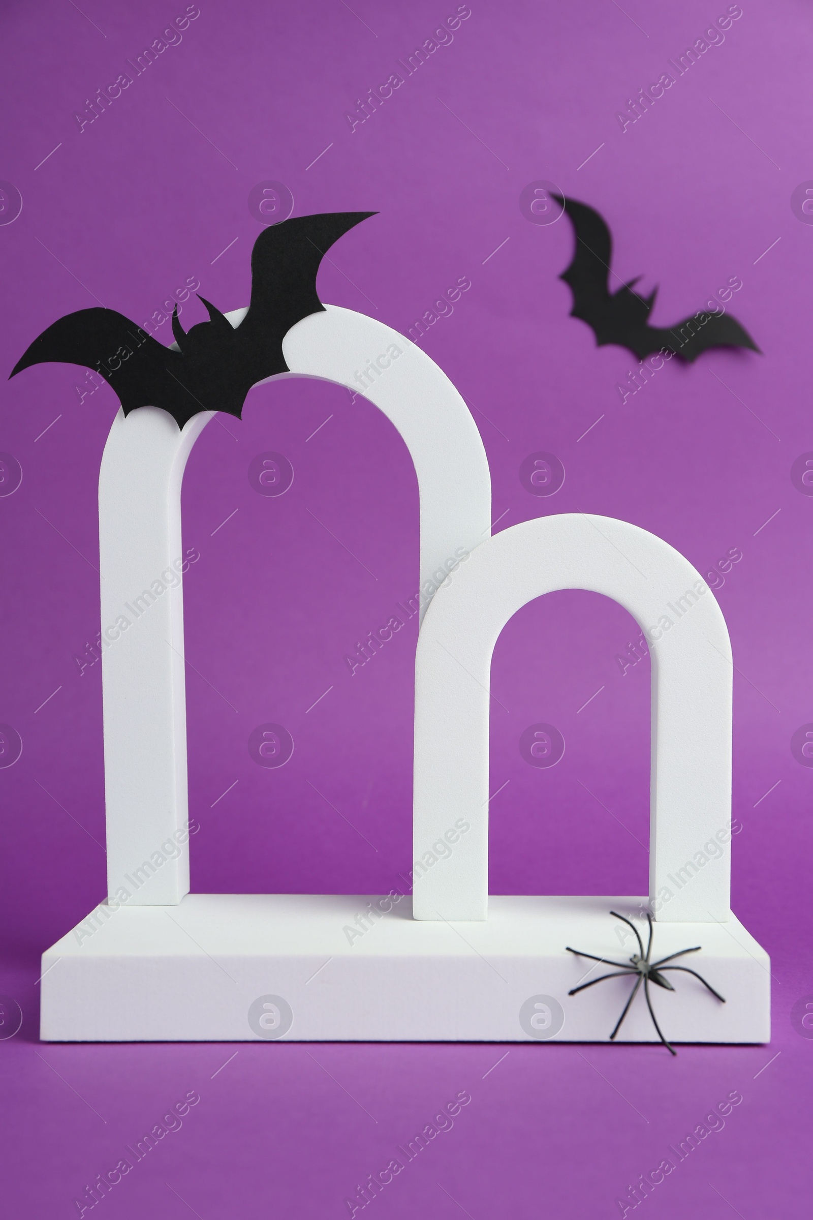 Photo of Presentation of product. Arches and Halloween decor on purple background. Space for text