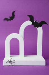 Photo of Presentation of product. Arches and Halloween decor on purple background. Space for text