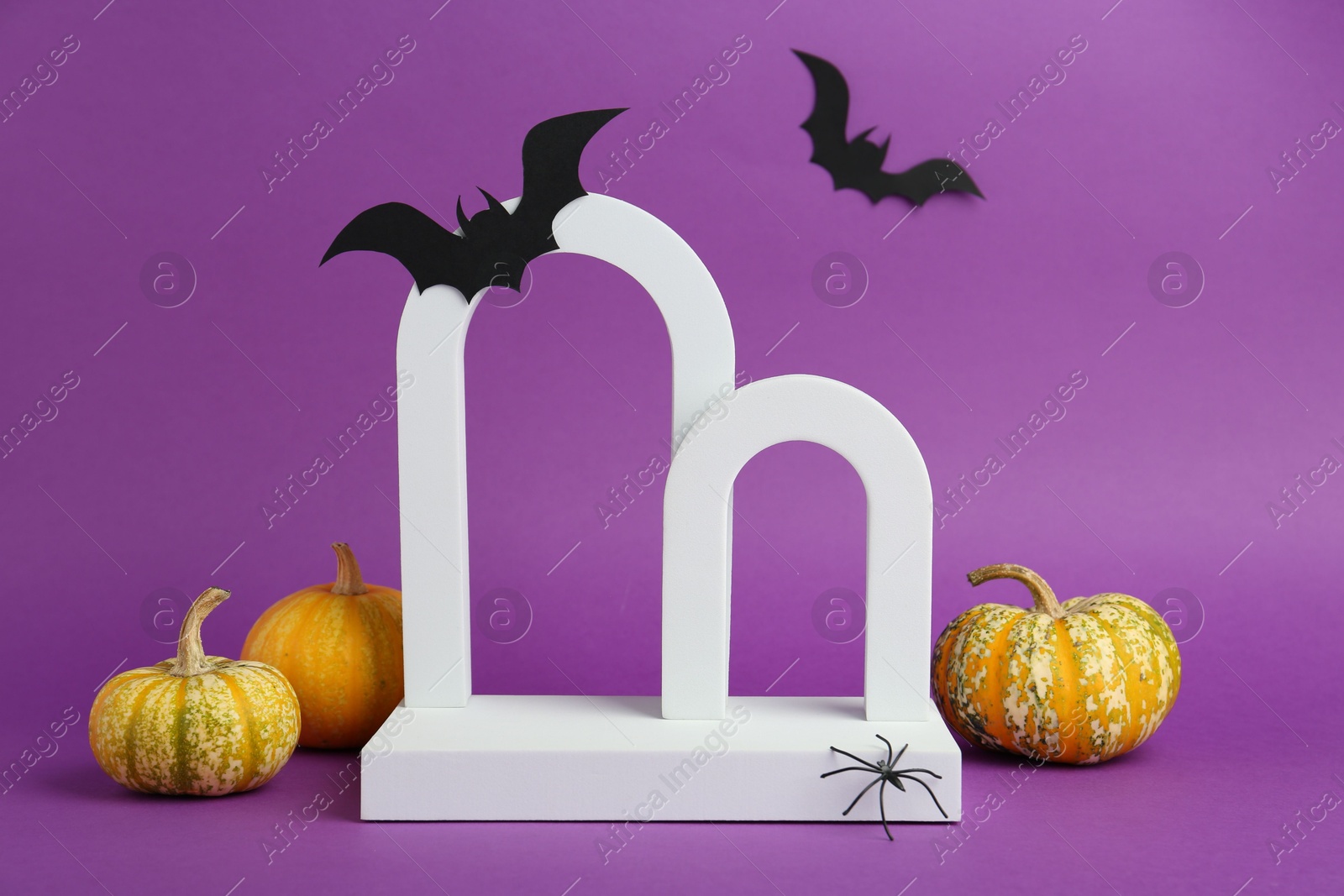 Photo of Presentation of product. Arches and Halloween decor on purple background. Space for text