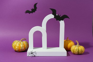 Photo of Presentation of product. Arches and Halloween decor on purple background. Space for text