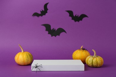 Photo of Presentation of product. Podium and Halloween decor on purple background. Space for text