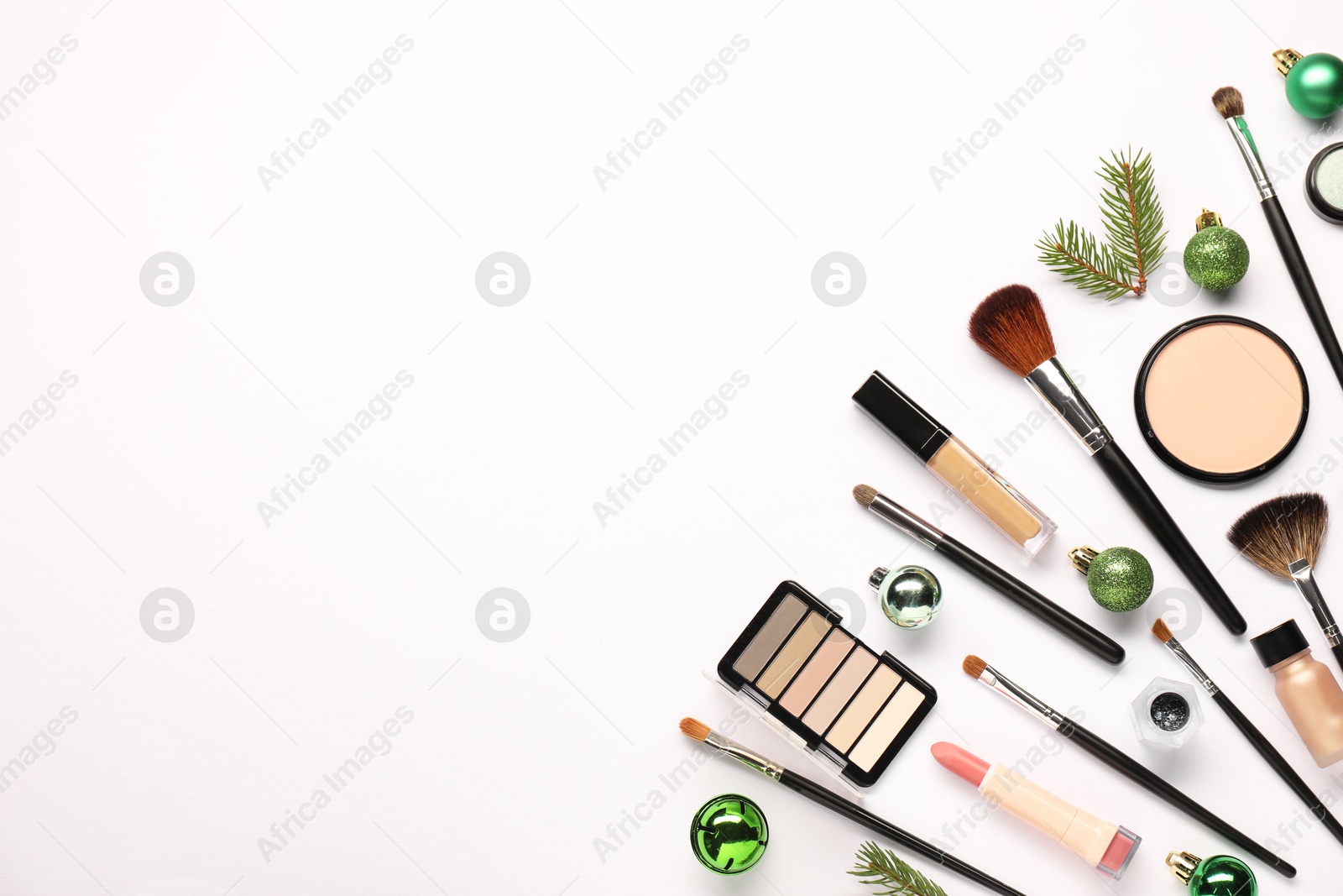 Photo of Different makeup brushes, decorative cosmetics and Christmas decor on white background, flat lay. Space for text