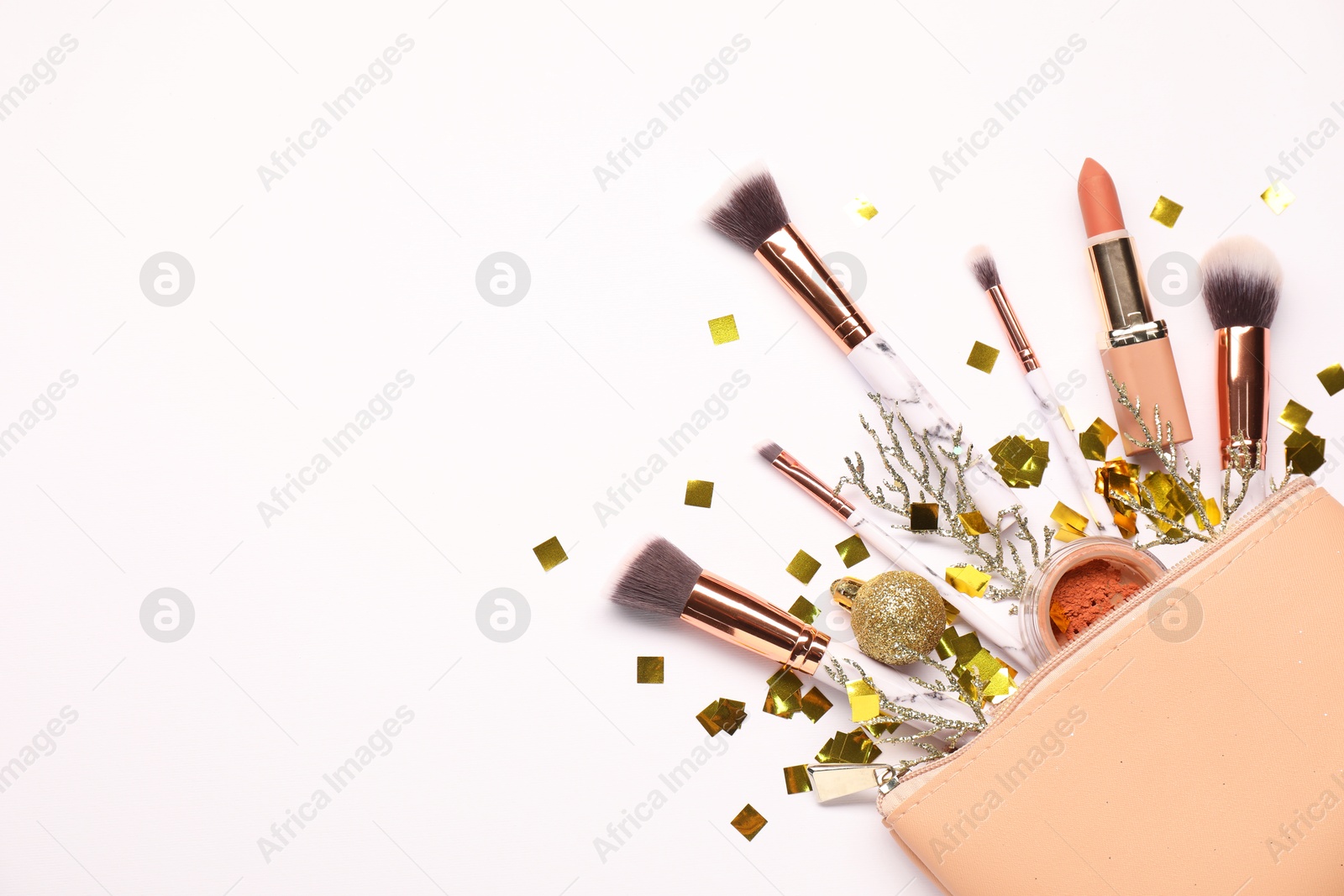 Photo of Cosmetic bag with makeup brushes, decorative cosmetics and Christmas decor on white background, top view. Space for text