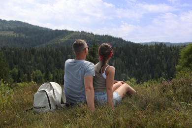 Photo of Couple with backpack enjoying picturesque landscape, back view. Active tourism