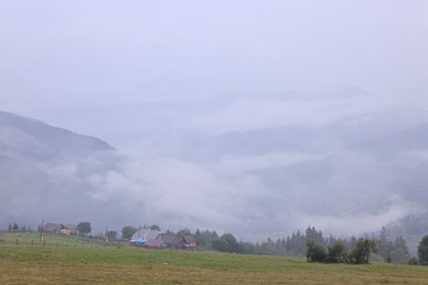 Photo of Picturesque view of beautiful mountains covered with fog