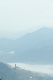 Picturesque view of beautiful mountains covered with fog