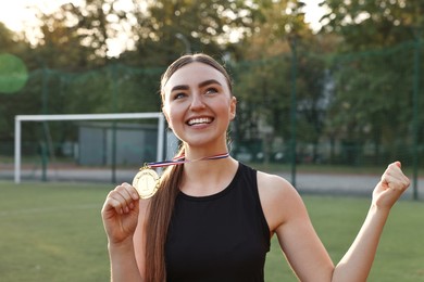 Photo of Happy winner with golden medal at stadium