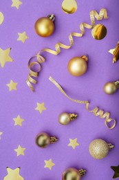 Photo of Beautiful Christmas baubles and confetti on purple background, flat lay