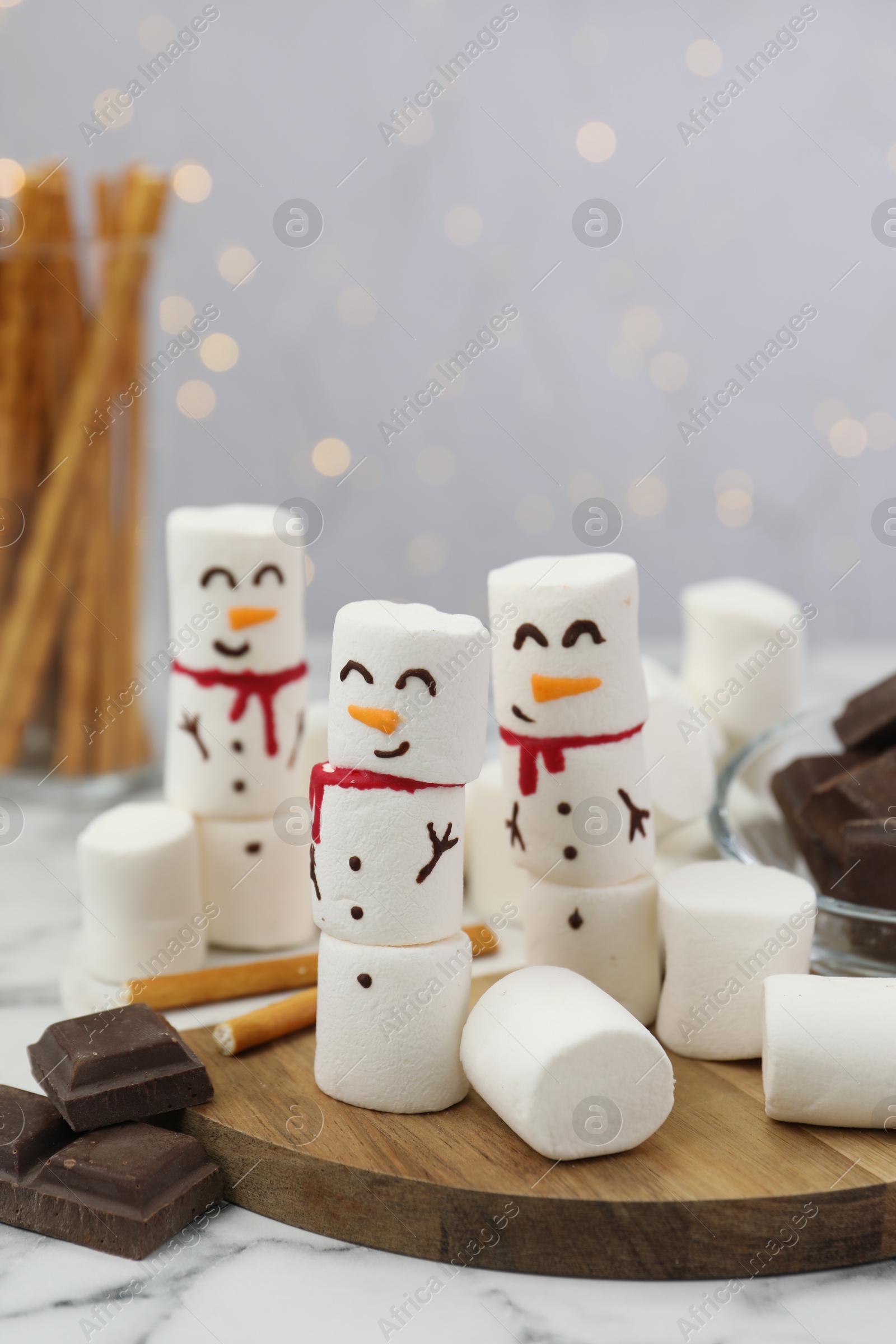 Photo of Funny snowmen made with marshmallows on white marble table