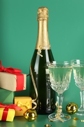 Photo of Sparkling wine, confetti and other Christmas decor on green background