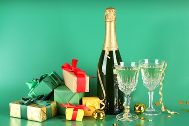 Photo of Sparkling wine, confetti and other Christmas decor on green background