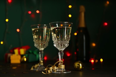 Photo of Glasses of sparkling wine on table against blurred lights