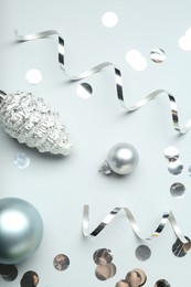 Photo of Flat lay composition with shiny confetti and other Christmas decor on light grey background